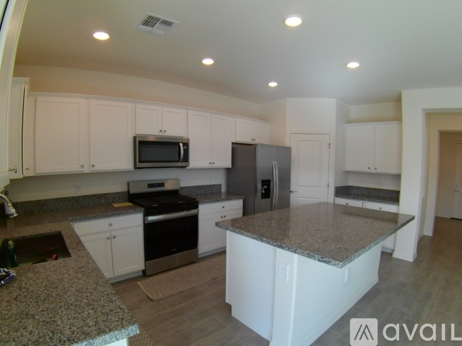 A kitchen with granite countertops and stainless steel appliances.