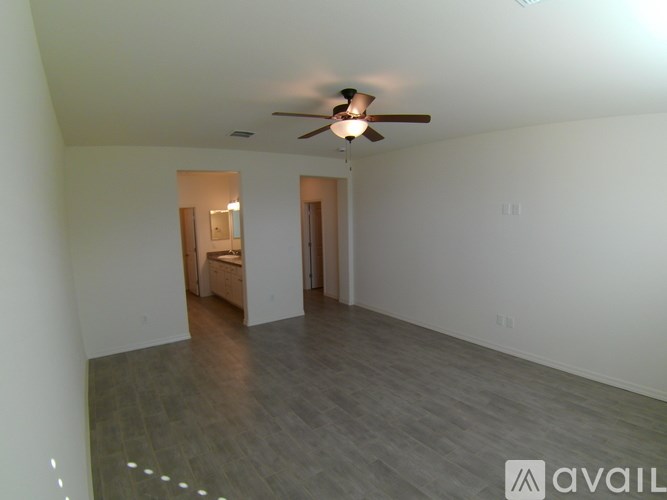A spacious room with a ceiling fan and a wooden floor.
