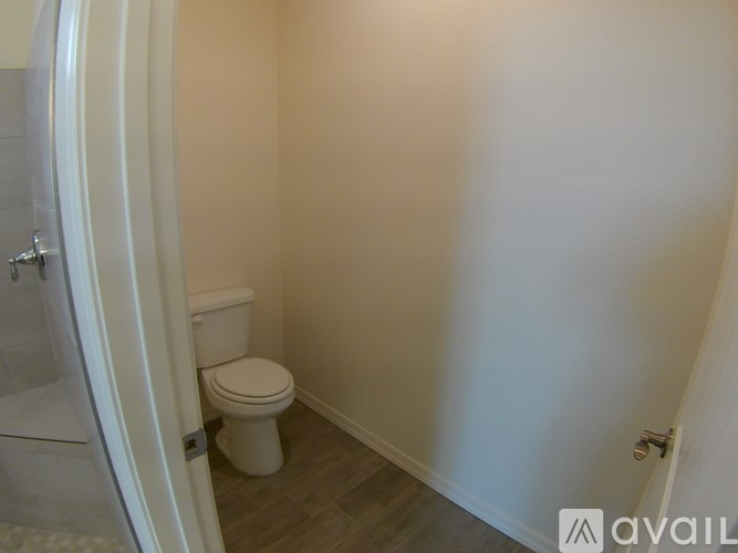 A white toilet is in a small bathroom.