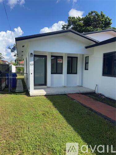 A white house with a red door and windows is for sale.