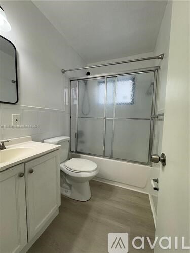 A white toilet in a bathroom with a glass shower door.