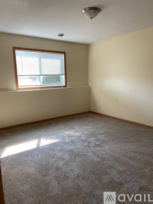 A room with a window and carpeted floor.