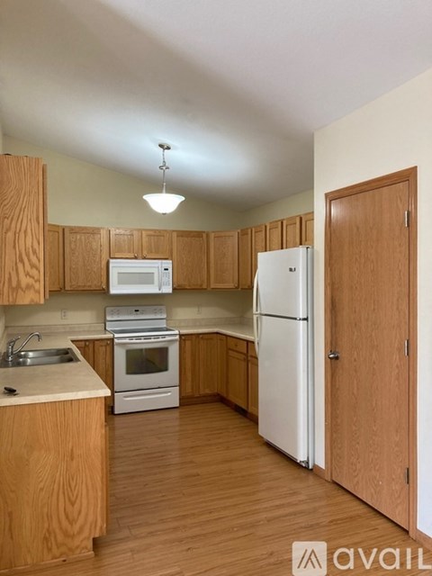 A kitchen with wooden cabinets and a white refrigerator.
