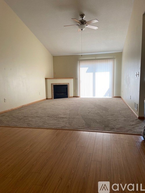 A room with a fireplace and a ceiling fan.