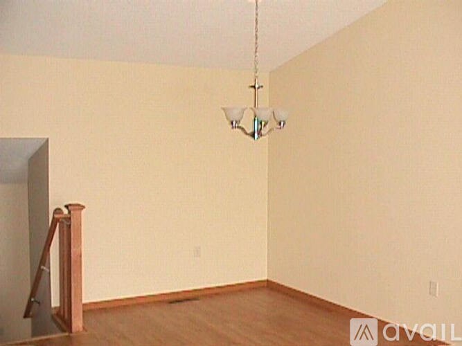 A room with a wooden floor and a chandelier hanging from the ceiling.