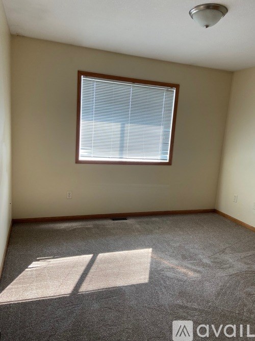 A room with a window and carpeted floor.