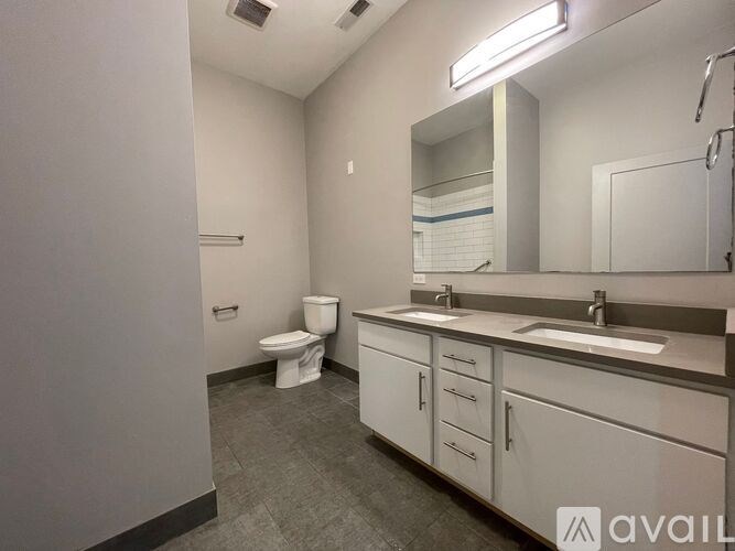 A bathroom with a toilet, sink, and mirror.