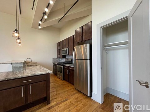 A kitchen with a refrigerator, microwave, and oven.