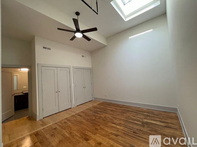 A room with a ceiling fan and wooden flooring.