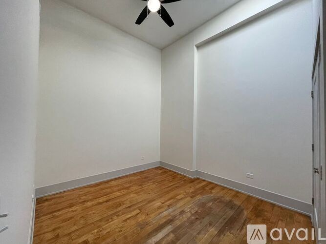 A room with wooden flooring and a ceiling fan.