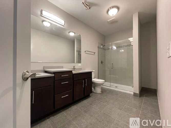 A bathroom with a toilet, sink, and mirror.