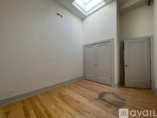 A room with wooden flooring and a skylight.