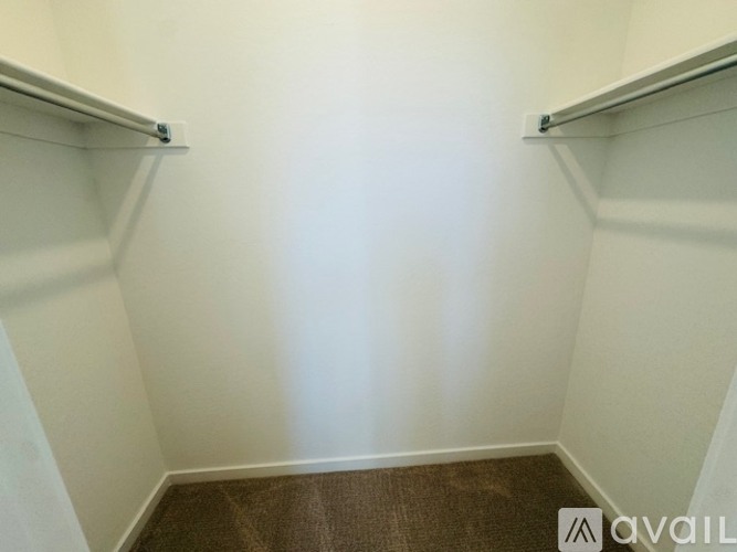 A small, empty room with a brown carpet.