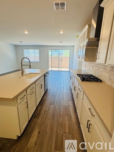 A kitchen with white cabinets and a wooden floor.