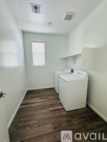 A small white cabinet with a toilet on top is in a room with wooden flooring.