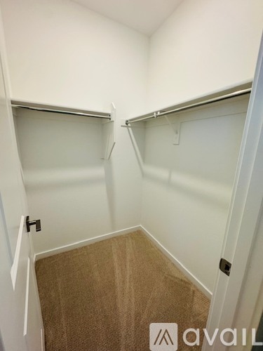 A small, empty room with a carpeted floor and white walls.