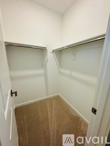 A small, empty room with a carpeted floor and white walls.