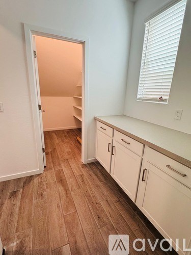 A room with a white door and cabinets.