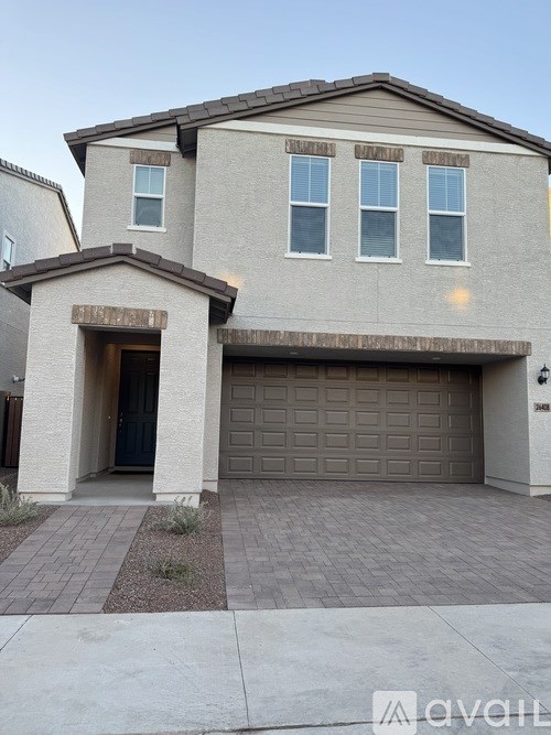 A two-story house with a garage door and a driveway.