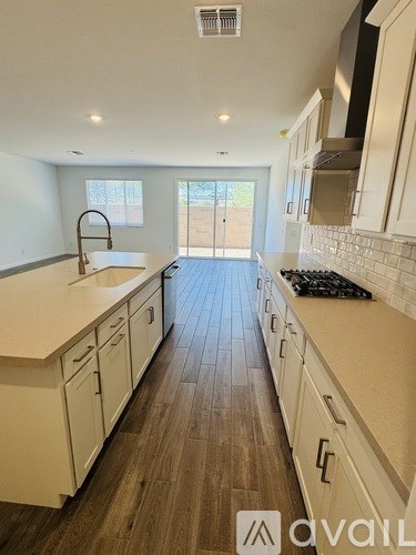 A kitchen with white cabinets and a wooden floor.