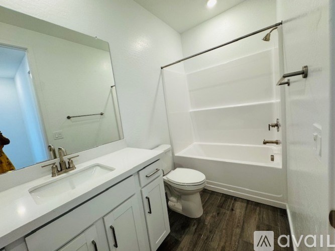 A white bathroom with a toilet, sink, and bathtub.
