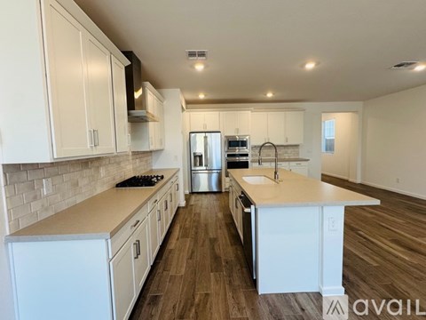 A kitchen with white cabinets and a wooden floor.