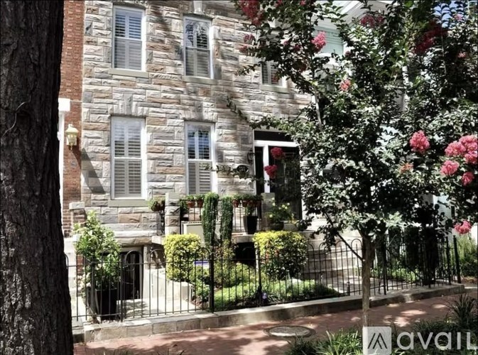 A stone building with a black iron fence and a gate.