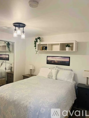 A bedroom with a bed, nightstands, and a framed picture on the wall.