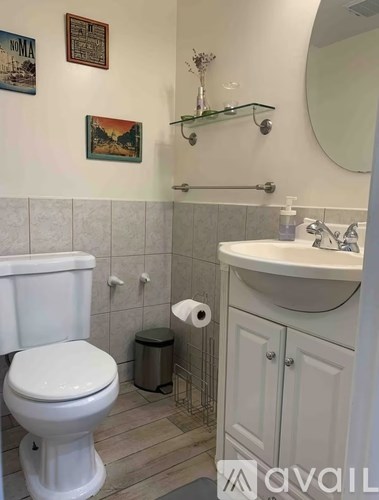 A white toilet sits next to a white sink in a bathroom.