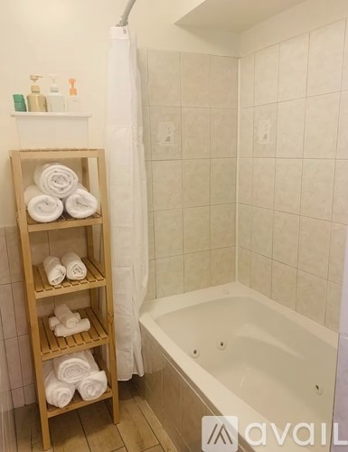 A bathroom with a white tub and towel rack.