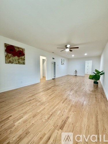A room with wooden flooring and a ceiling fan.