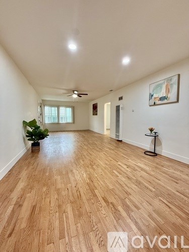 A room with wooden flooring and a ceiling fan.