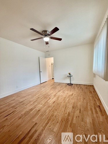 A room with wooden flooring and a ceiling fan.