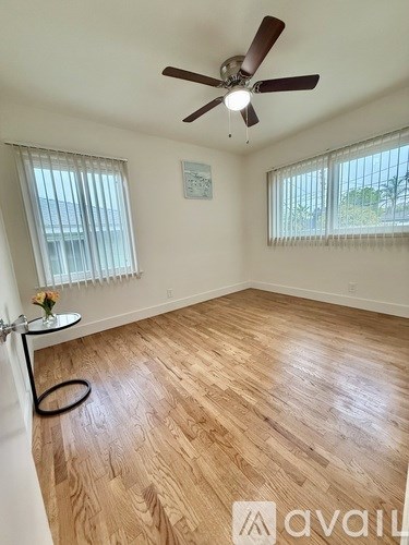 A room with wooden flooring and a ceiling fan.