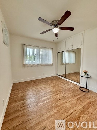 A room with wooden flooring and a ceiling fan.
