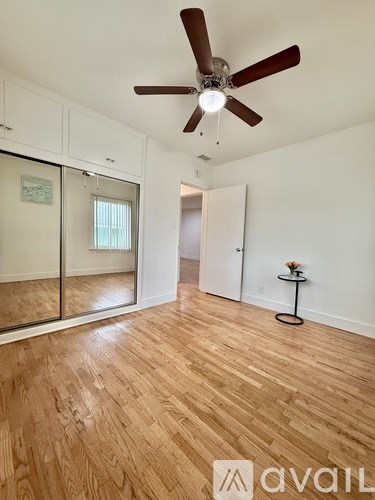 A room with wooden flooring and a ceiling fan.