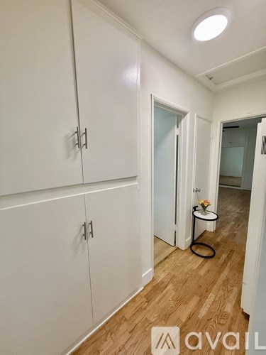 A white cabinet with a black handle is on the wall.