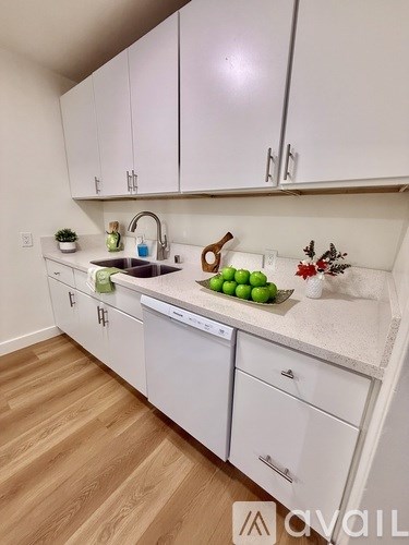 A kitchen with white cabinets and a sink.