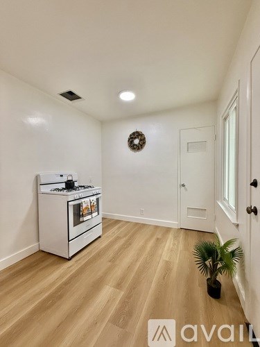 A kitchen area with a white cabinet and a plant.