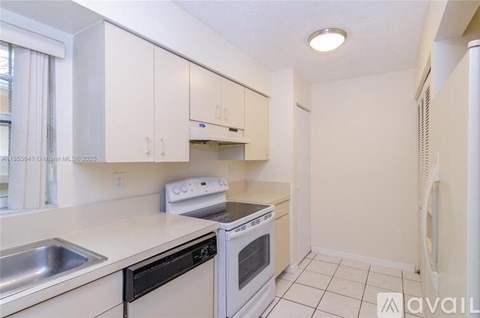 A kitchen with white cabinets and appliances.