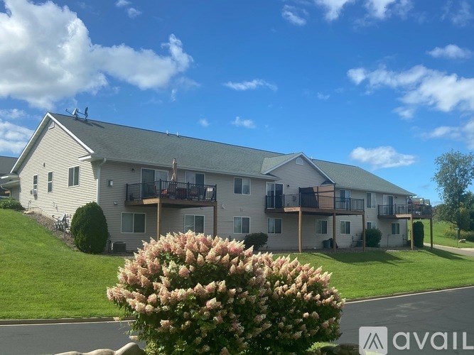 A building with a green roof and a balcony with a railing.