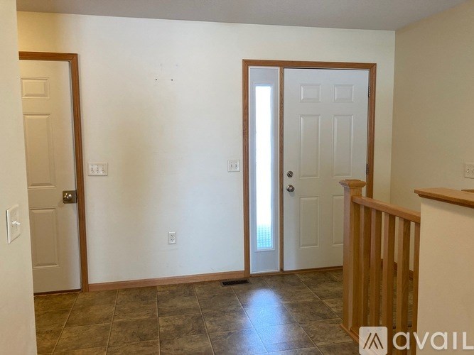 A room with a tiled floor and a wooden railing.