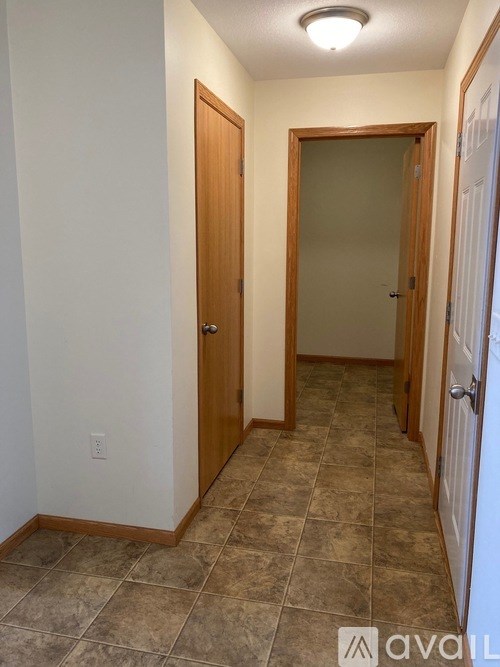A hallway with tiled floors and two doors.