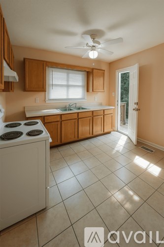 A kitchen with a white dishwasher and wooden cabinets.