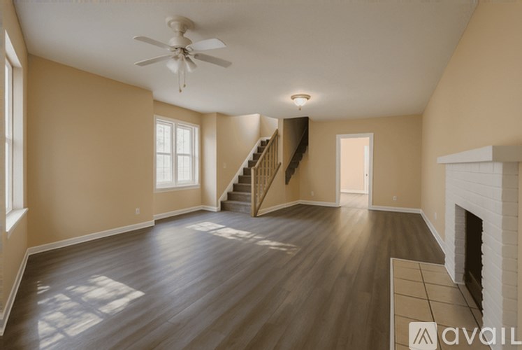 A spacious living room with wood flooring and a fireplace.