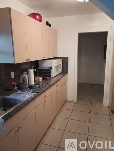 A kitchen with beige cabinets and a white oven.