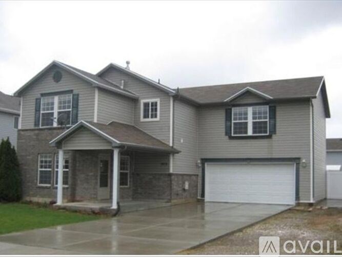 A two-story house with a garage is available for sale.