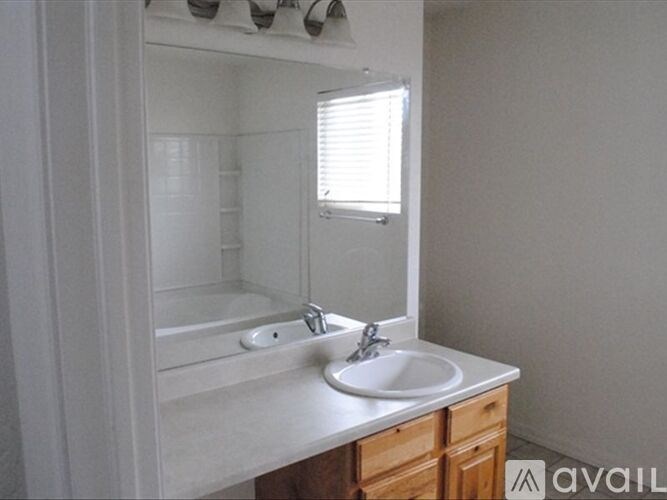 A bathroom with a sink, mirror, and bathtub.