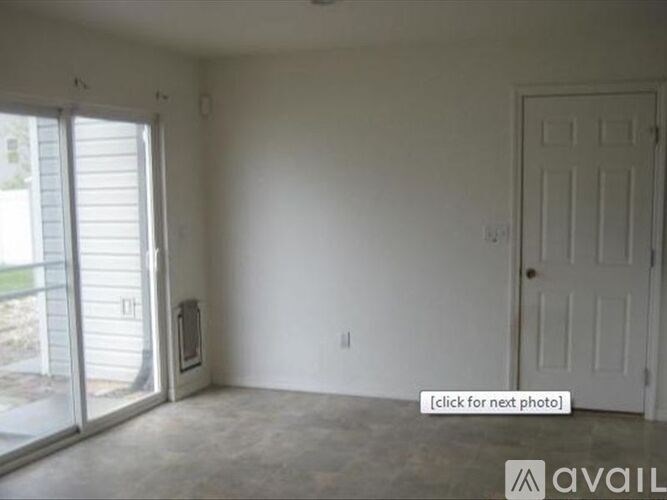 A room with a sliding glass door and a white door.
