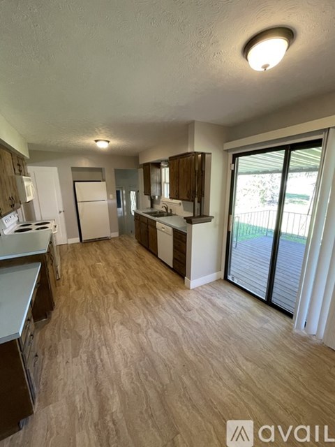A kitchen with wooden cabinets and a white fridge is shown.